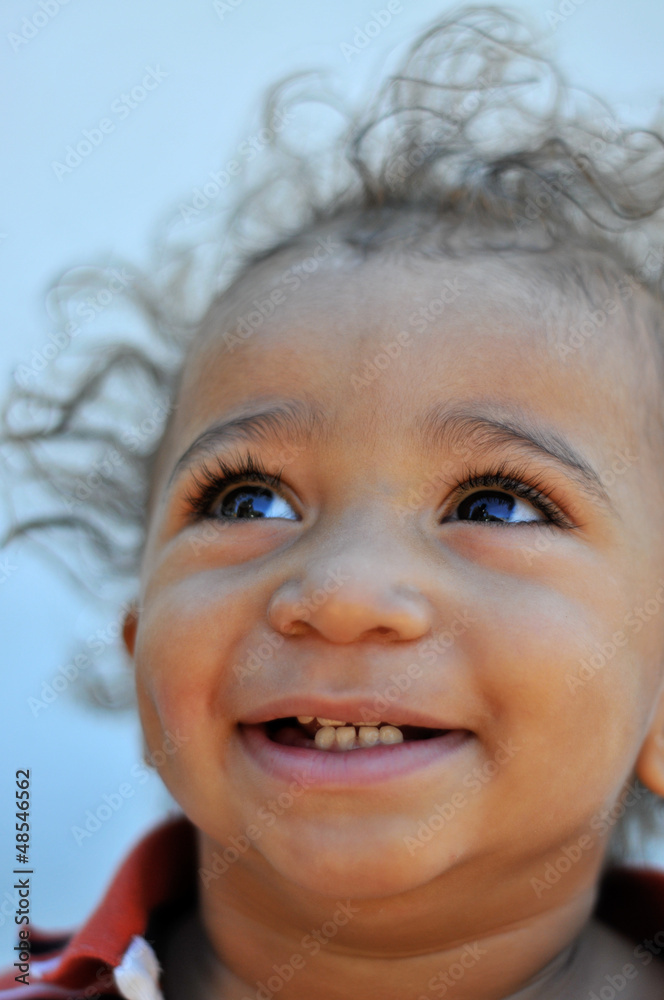 Child with wild hair smiling and looking up Child with wild hair smiling and looking up