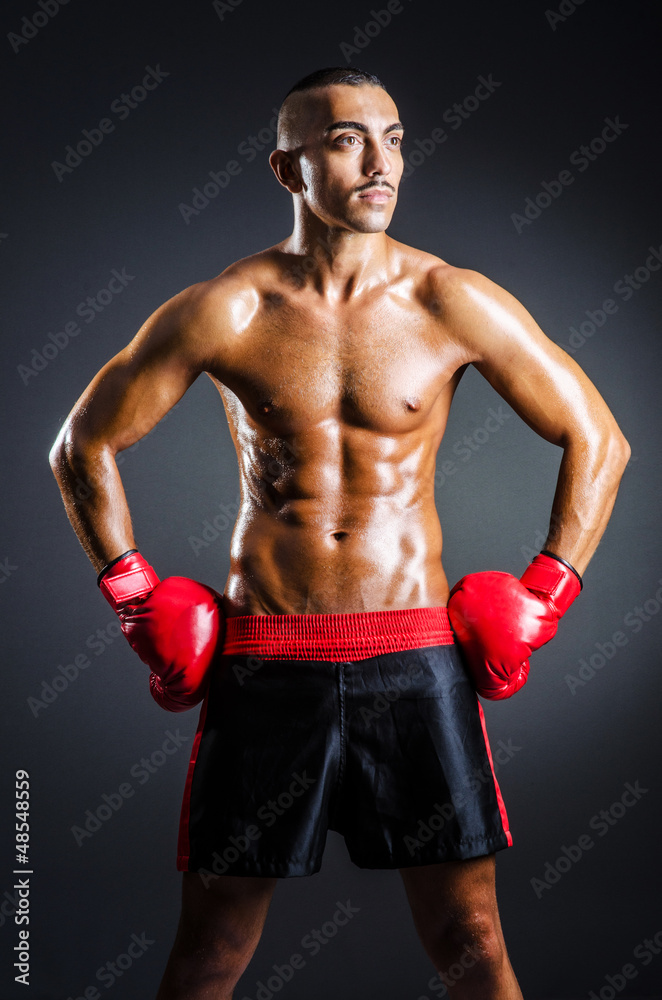 Boxer with red gloves in dark room