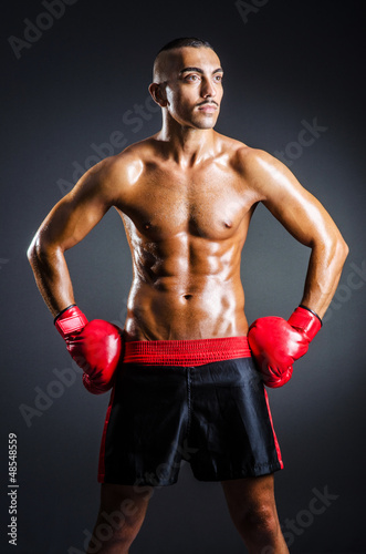 Boxer with red gloves in dark room © Elnur