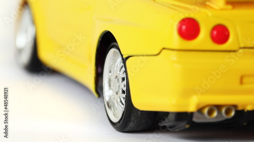 wheel of yellow toy radio-controlled car rotates back and forth photo