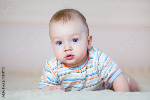 cute baby boy lying on stomach