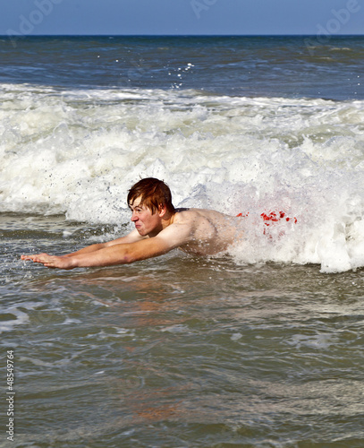 young boy is body surfing in the waves © travelview