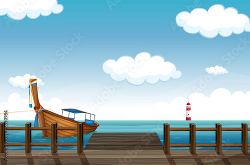 Fotografia A docked boat and lighthouse