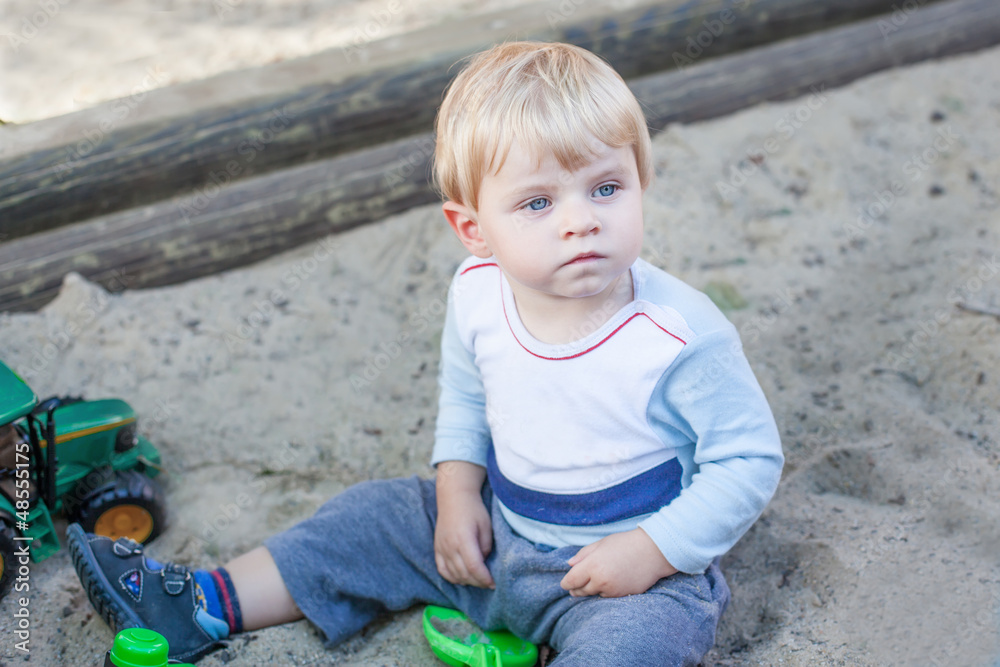 Little toddler boy playing with sand and toy Little toddler boy playing with sand and toy