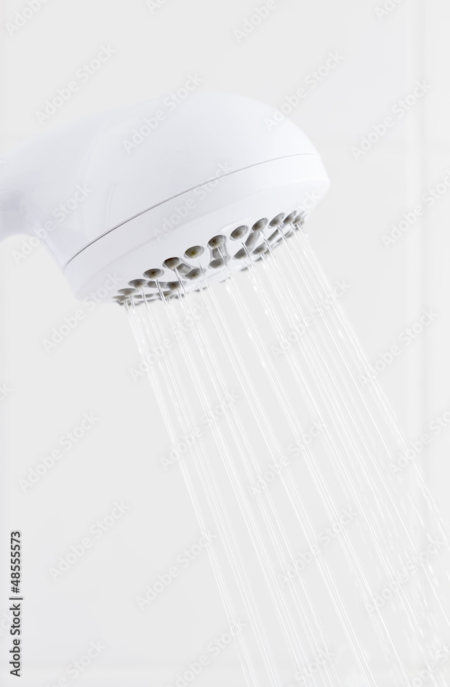 Water flowing from bathroom white plastic shower head Water flowing from bathroom white plastic shower head