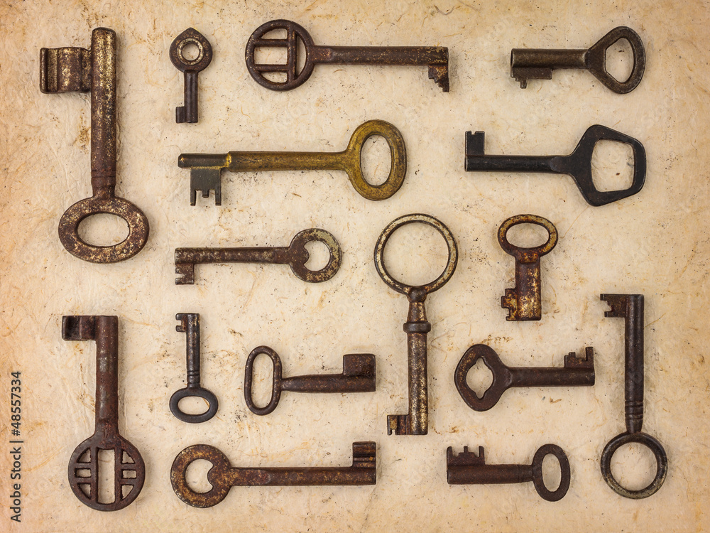 Different antique keys on a retro paper background Different antique keys on a retro paper background