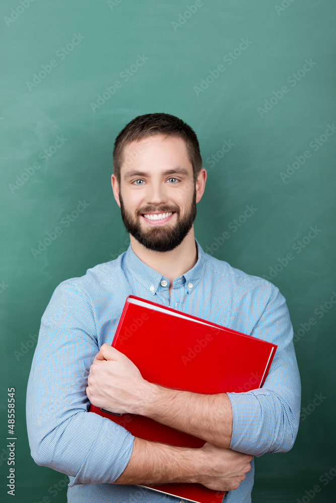 lächelnder student mit aktenordner vor der tafel lächelnder student mit aktenordner vor der tafel