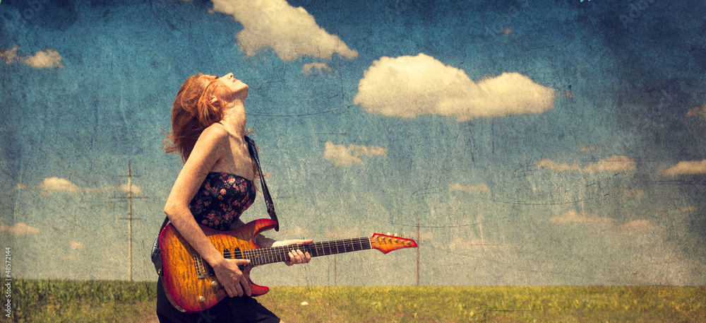Red-head girl with guitar. Photo in old image style.