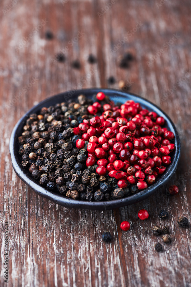 Black and pink peppercorns on a small plate Black and pink peppercorns on a small plate