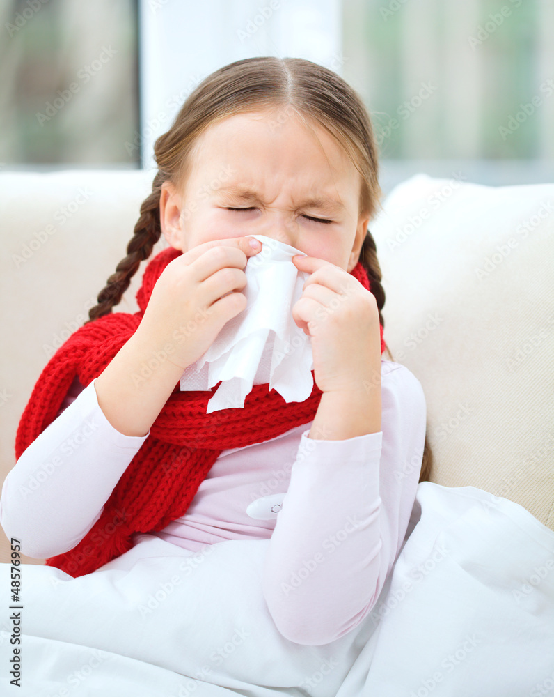 Little girl is blowing her nose