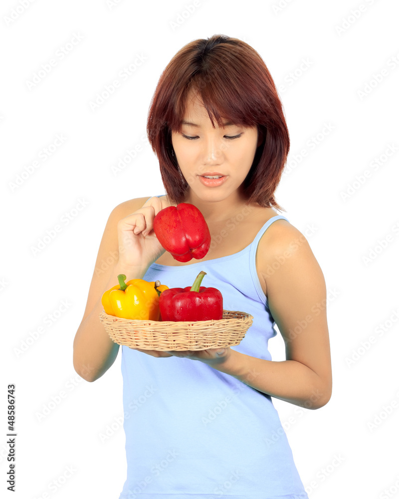 Isolated young asian woman with a red and yellow paprika Isolated young asian woman with a red and yellow paprika