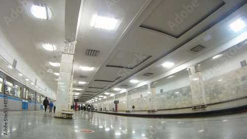 Passengers go on ladder on subway station where three railway photo