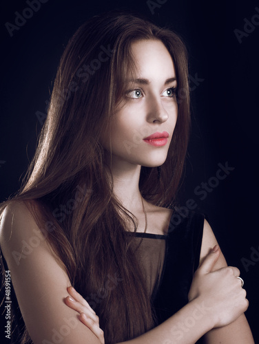 beautiful girl with long hair against black background