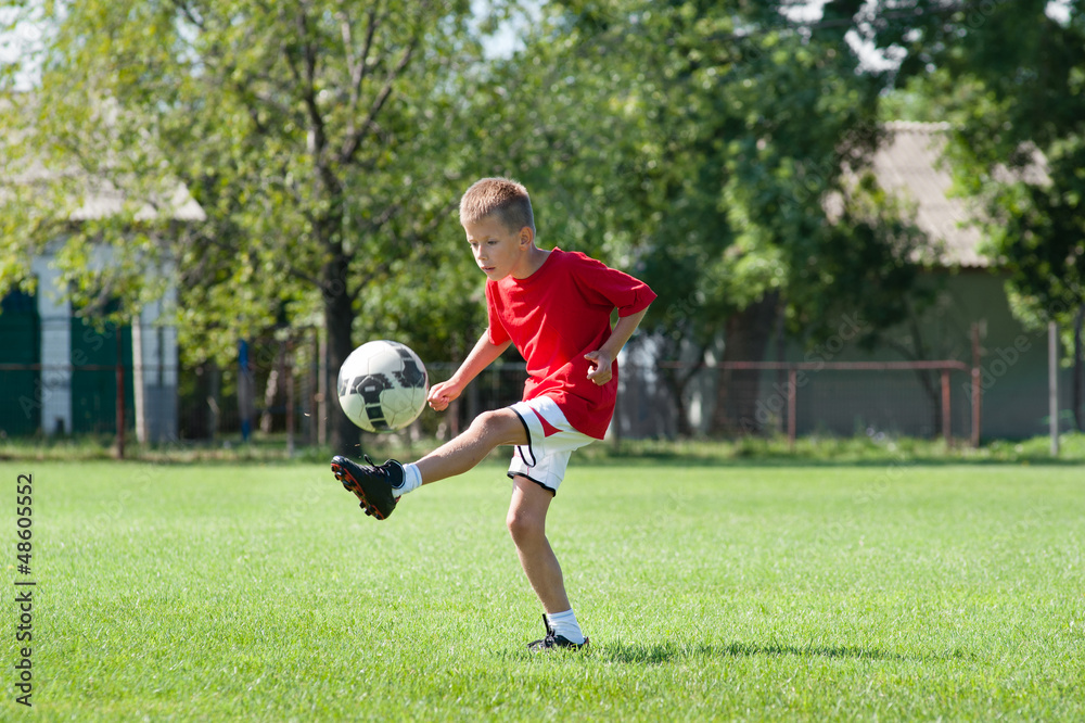 boy kicking football