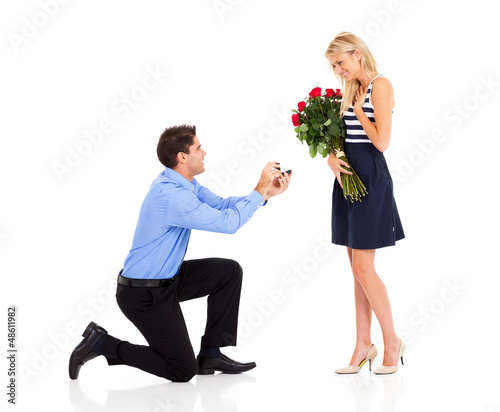 young man down on his knee proposing to girlfriend