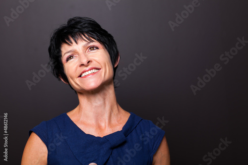 optimistic middle aged woman portrait on black background © michaeljung