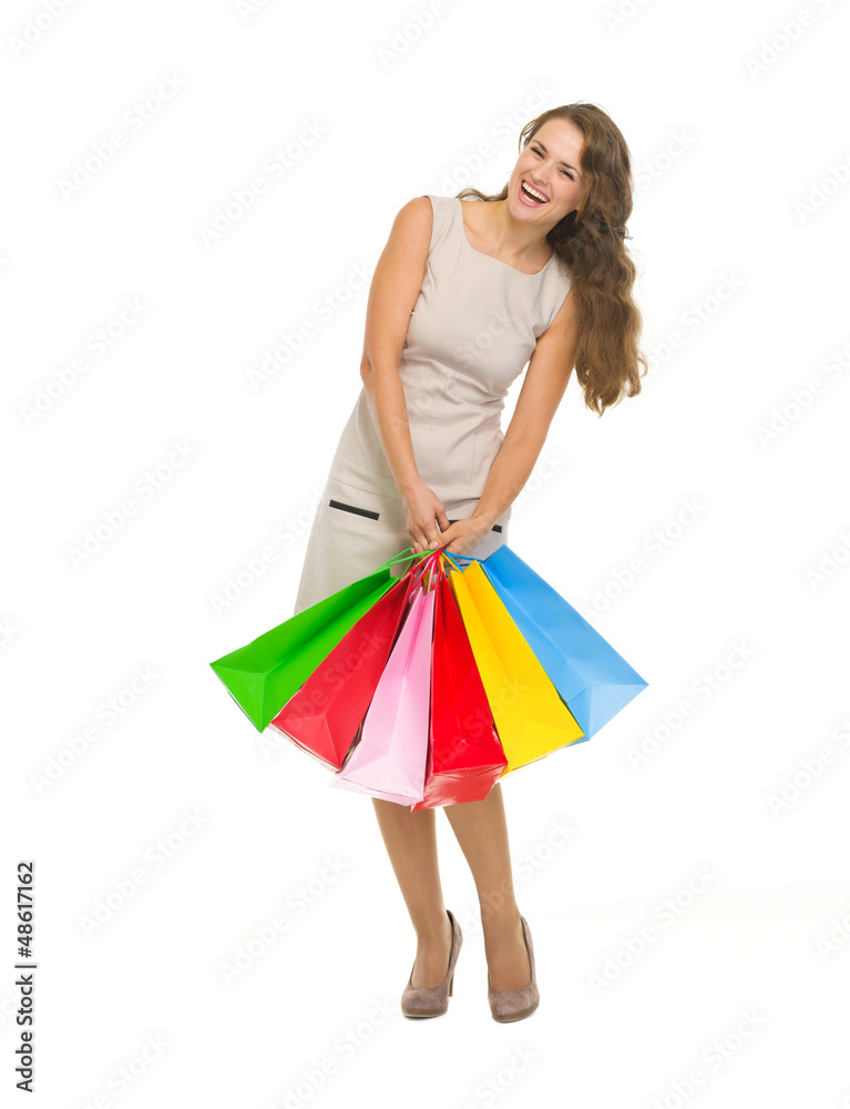 Full length portrait of happy young woman holding shopping bags