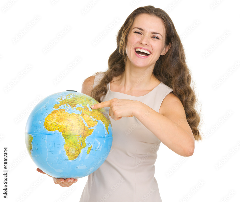 Smiling young woman pointing on globe Smiling young woman pointing on globe