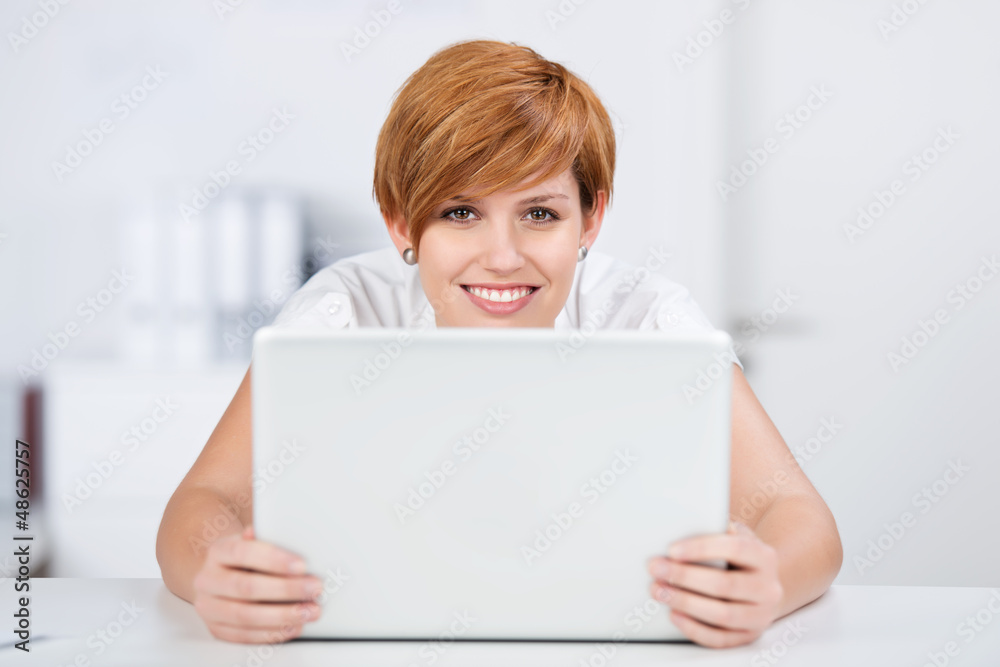 lächelnde frau mit laptop am schreibtisch lächelnde frau mit laptop am schreibtisch