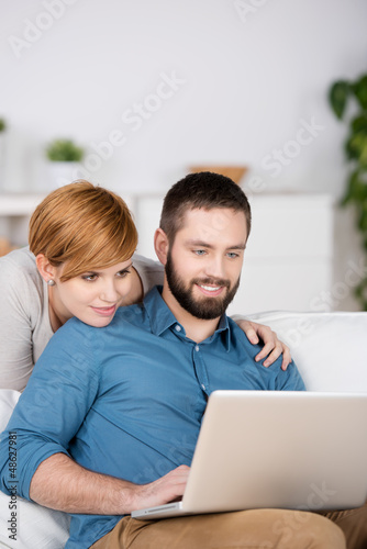 junges paar schaut auf laptop