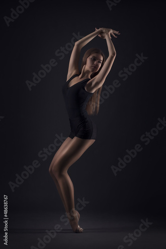 cute woman gymnast on dark background