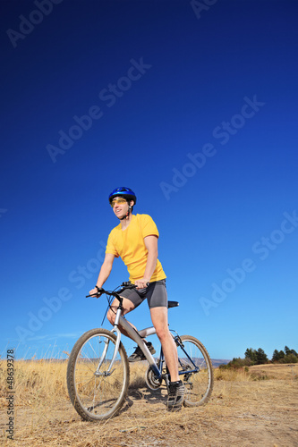 Panning shot of a bicycle rider riding a bike outdoors