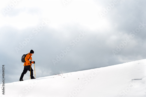 Hiker going up on a slope photo