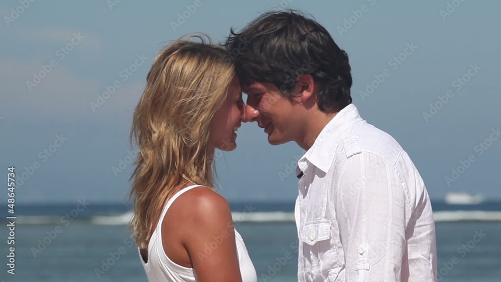 Happy woman and man looking at each other and hugging at beach Happy woman and man looking at each other and hugging at beach