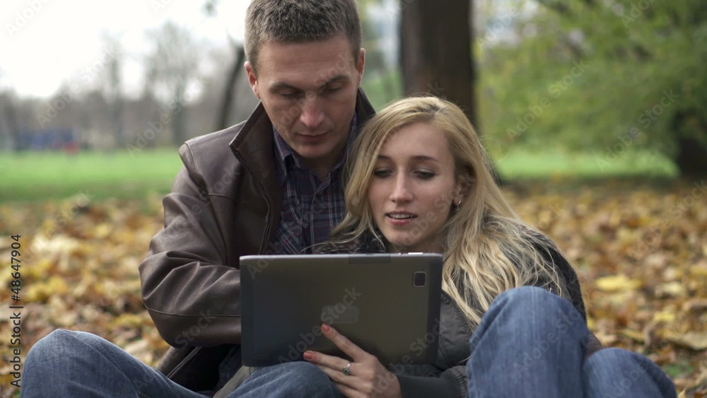 Young couple with tablet computer in autumn park Young couple with tablet computer in autumn park