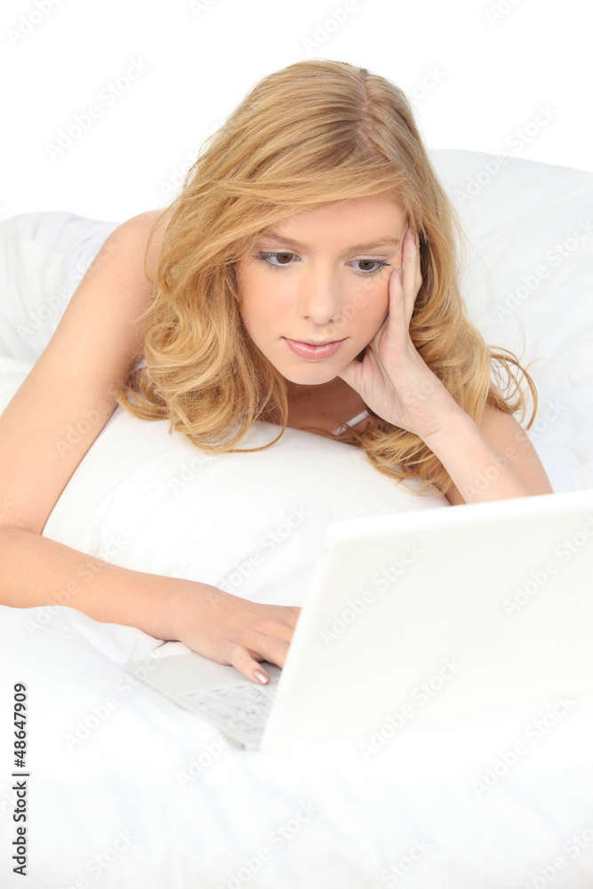 Woman with computer in bed Woman with computer in bed