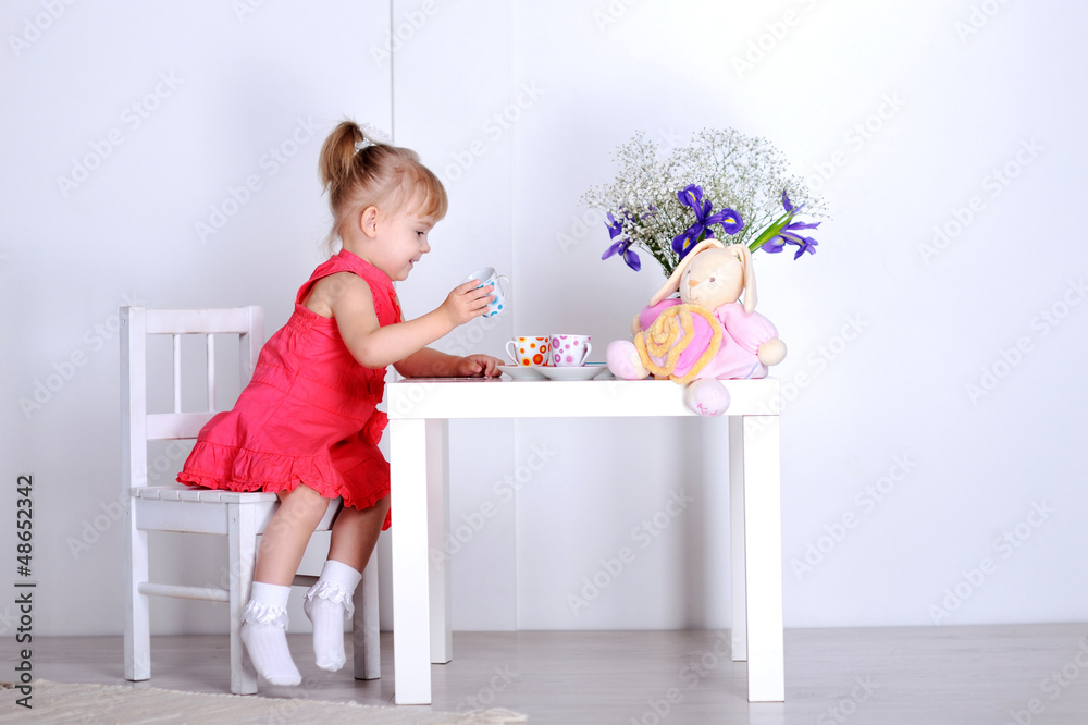 A little girl plays with dolls and dishes A little girl plays with dolls and dishes