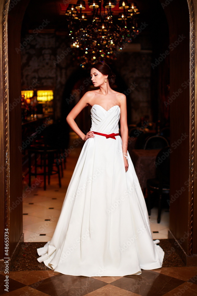 Naklejka premium sexy happy bride in white wedding dress in interior