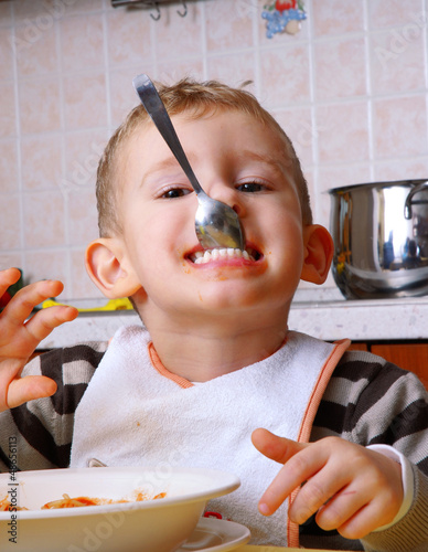 Gracioso niño comiendo en la cocina,alimentación de un niño.