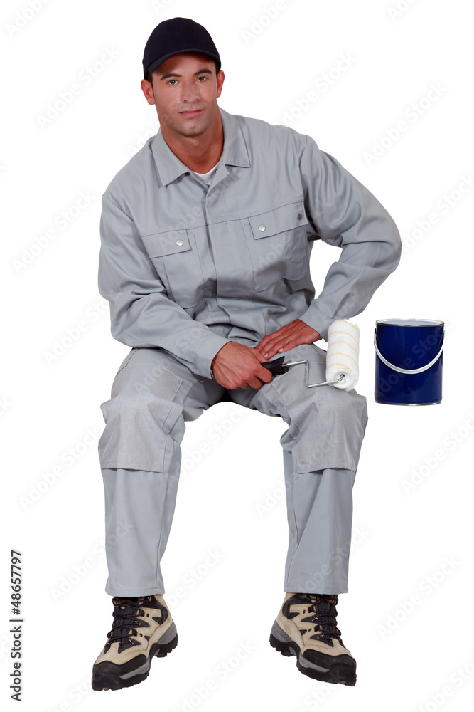 Painter sitting with hand roller Painter sitting with hand roller