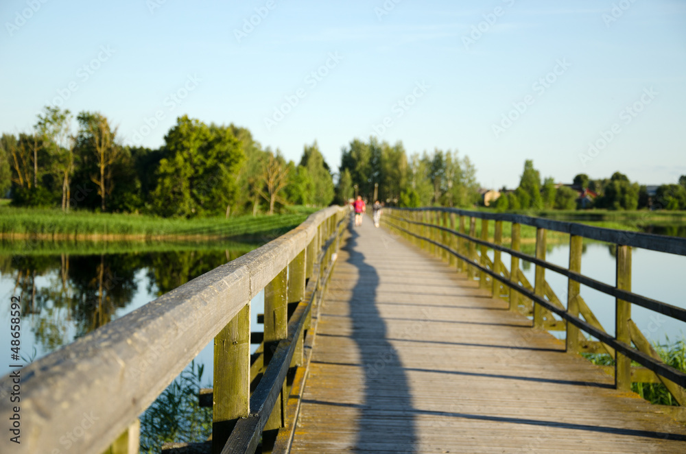 wooden footbridge railings lake blur people walk wooden footbridge railings lake blur people walk