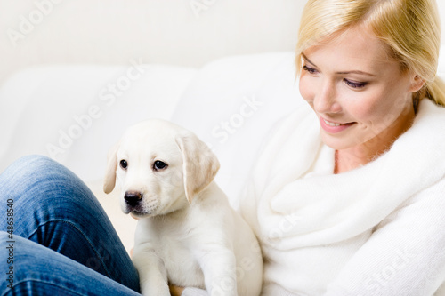 Close up of woman in white sweater with puppy 