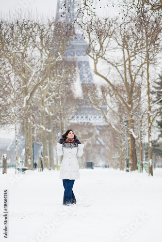 Fototapeta Naklejka Na Ścianę i Meble -  Beautiful girl in fur hood walking near the Eiffel tower in Pari