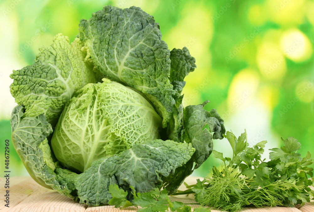 Fresh savoy cabbage on wooden table on natural background Fresh savoy cabbage on wooden table on natural background