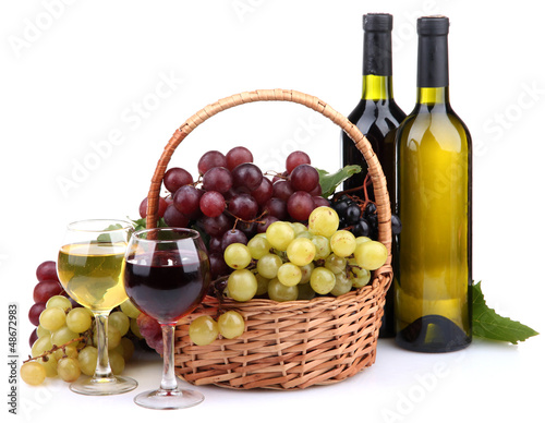 bottles and glasses of wine and grapes in basket, isolated