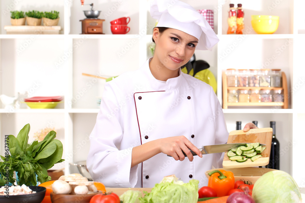 Young woman chef cooking in kitchen Young woman chef cooking in kitchen