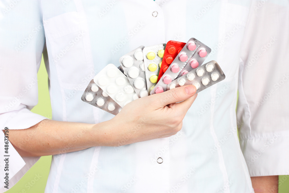 Close-up of female doctor hand holding pills,