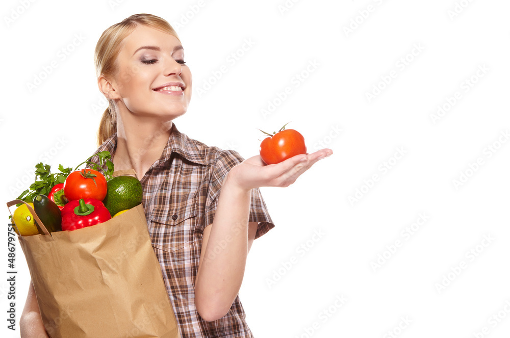 Woman with a shopping bag filled with nutritious fruit and veget Woman with a shopping bag filled with nutritious fruit and veget
