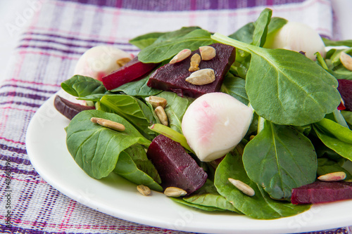 Fresh salad with roasted beets, spinach, mozzarella and seeds