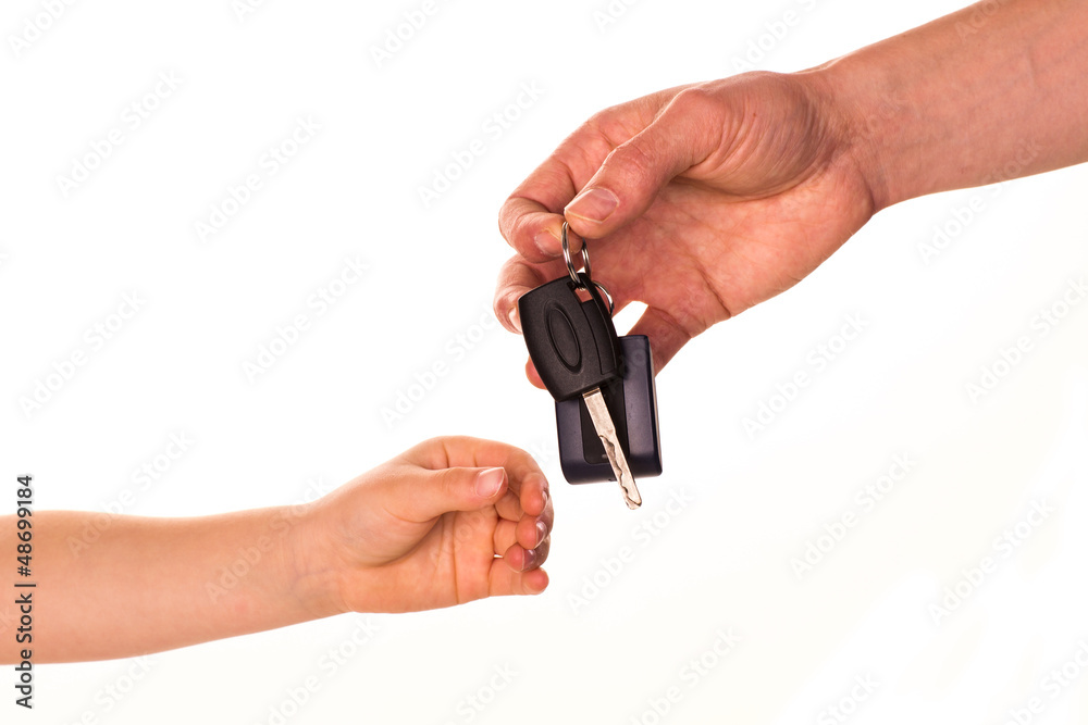 Male hand holding a car key and handing it over Male hand holding a car key and handing it over