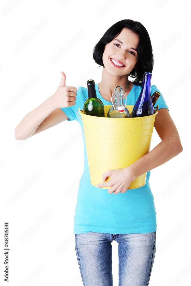 Woman carrying a bin with recyclable glass bottles. Woman carrying a bin with recyclable glass bottles.