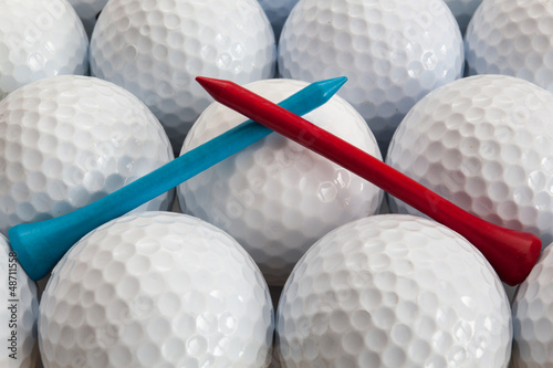 An closeup of a regular a blue and red golf tees on a golf balls