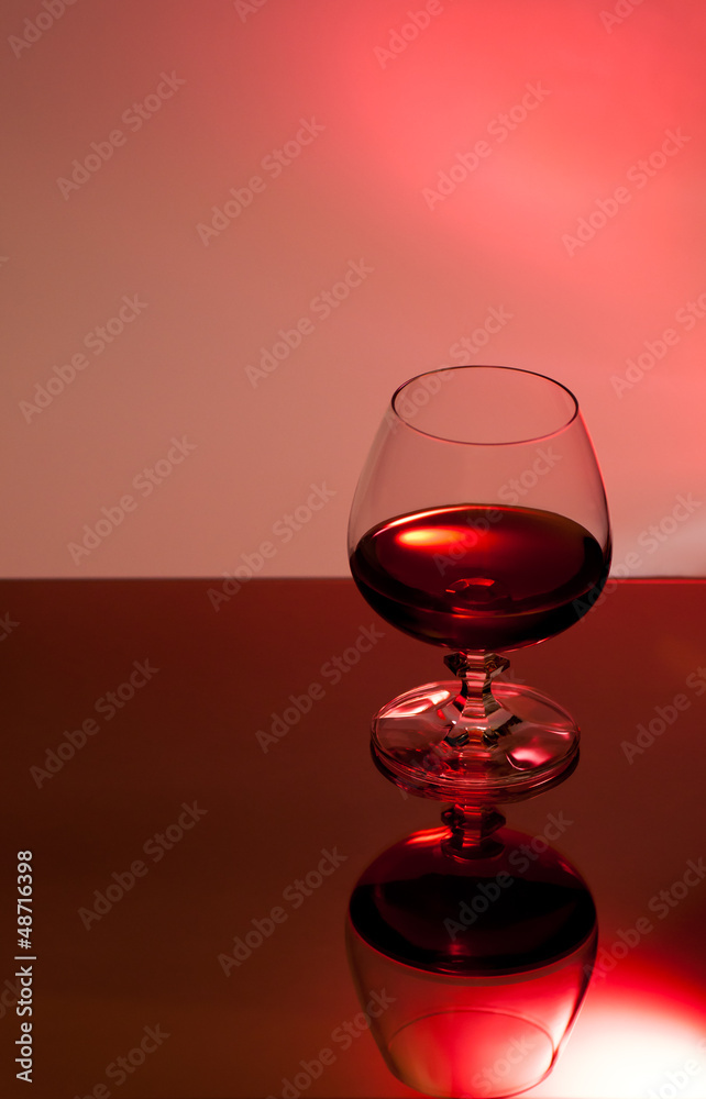Ein Glas mit Alkohol vor rotem Hintergrund Ein Glas mit Alkohol vor rotem Hintergrund