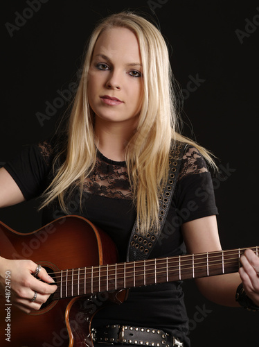Attractive female playing acoustic guitar
