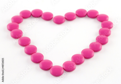 Pink tablets on a white paper