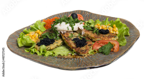 Roasted cutlets of potato with salmon on a plate